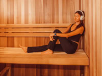 Girl sitting in Rambler Austin sauna listening to music