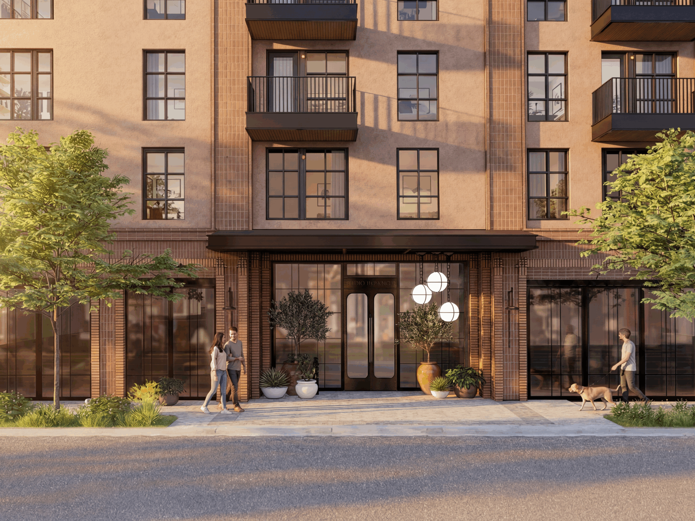 A modern apartment building facade with large windows, balconies, and a main entrance on East 5th St. Two people walk on the sidewalk—one with a dog—surrounded by greenery and potted plants, in warm afternoon light.
