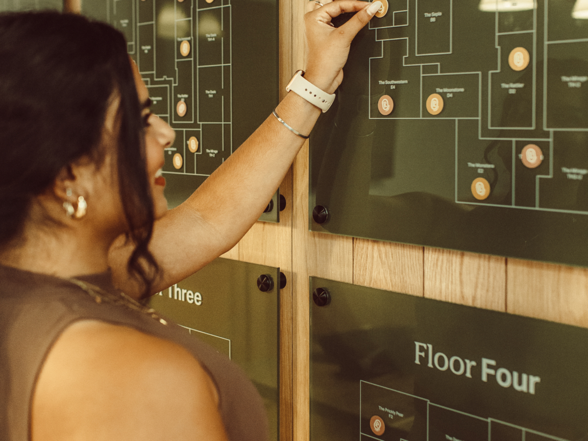 Rambler ATX resident putting sticker on floor plates in the leasing office