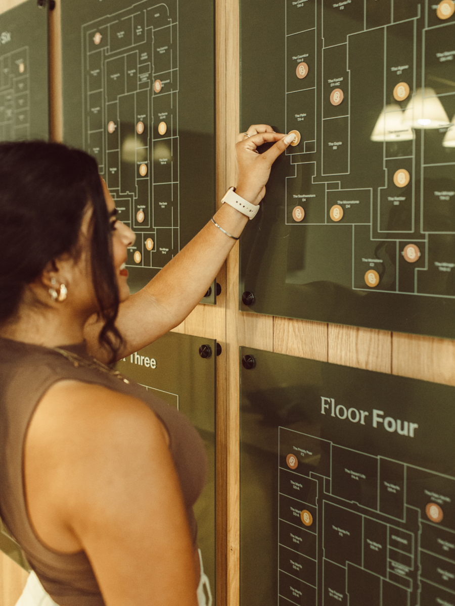 Rambler ATX resident putting sticker on floor plates in the leasing office