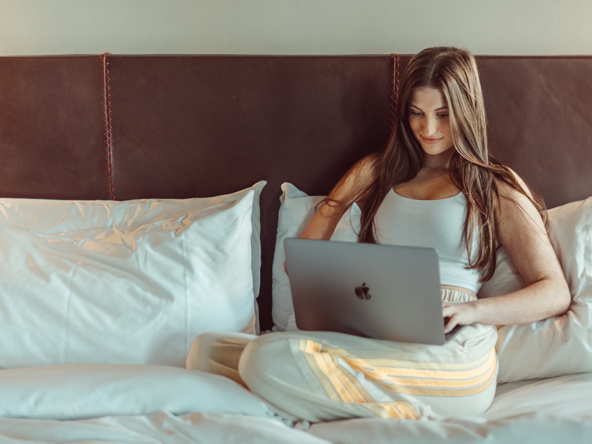 girl on computer in bed