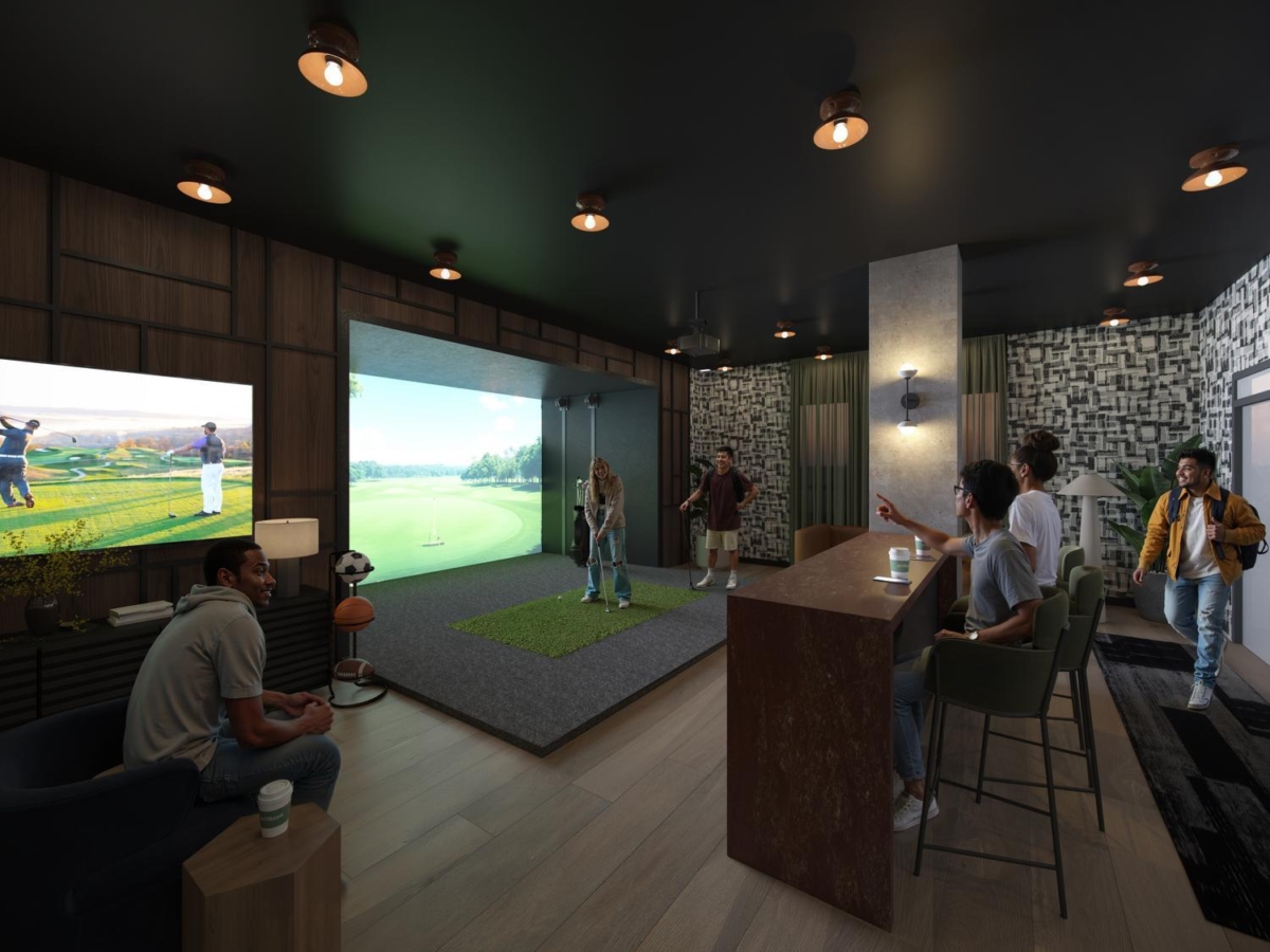 A group of people socializes in the stylish indoor golf simulator room at Rambler Riverfront. Some play virtual golf on large screens while others relax at the bar with drinks, surrounded by modern lighting, wood floors, and contemporary decor.