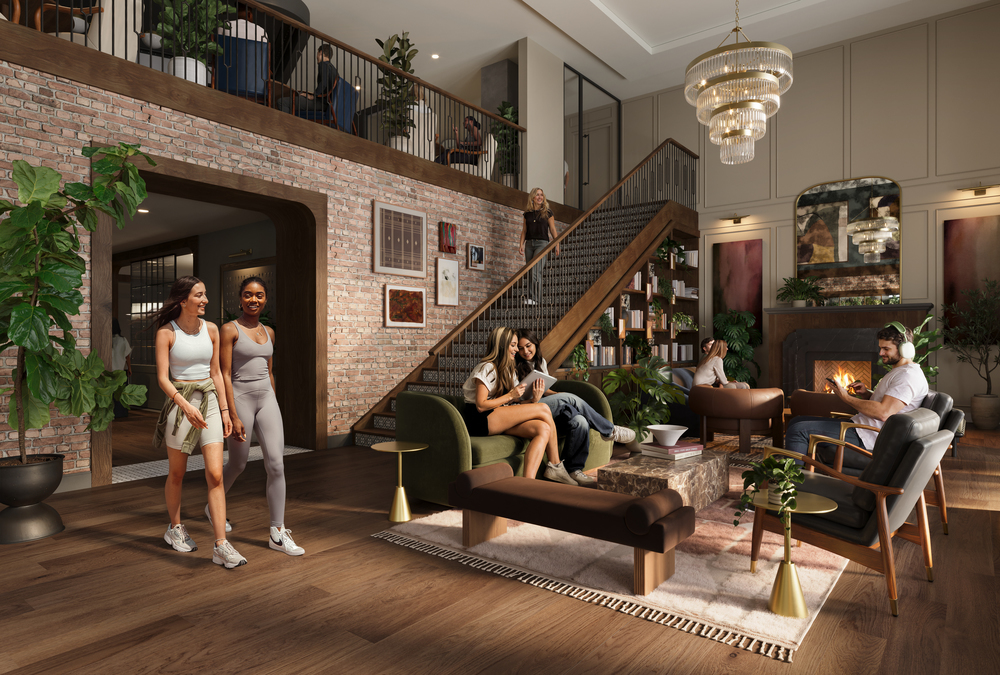 A stylish, modern lounge at Rambler Riverfront features large windows, lush plants, and a grand staircase. People are socializing: two women walk together, a couple relaxes on the sofa, and friends gather by the fireplace under elegant chandeliers.