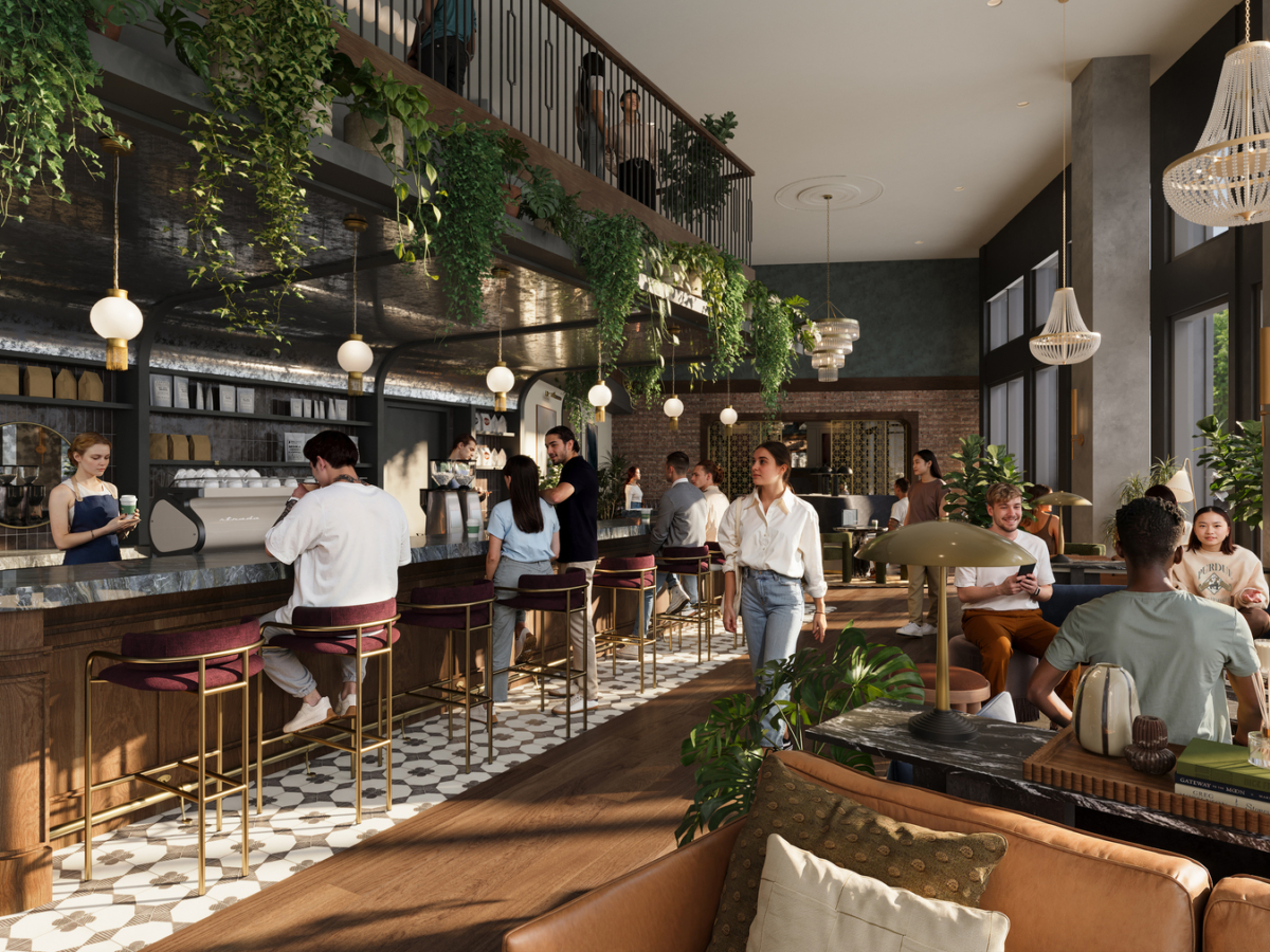 A stylish, modern café at Rambler Riverfront with people socializing. Customers sit at a marble bar and on sofas, surrounded by lush green plants and elegant lighting. Large windows let in natural light, creating a warm, inviting atmosphere.