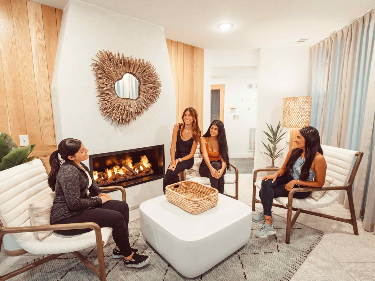 Girls sitting and chatting in Rambler Austin fireplace lounge