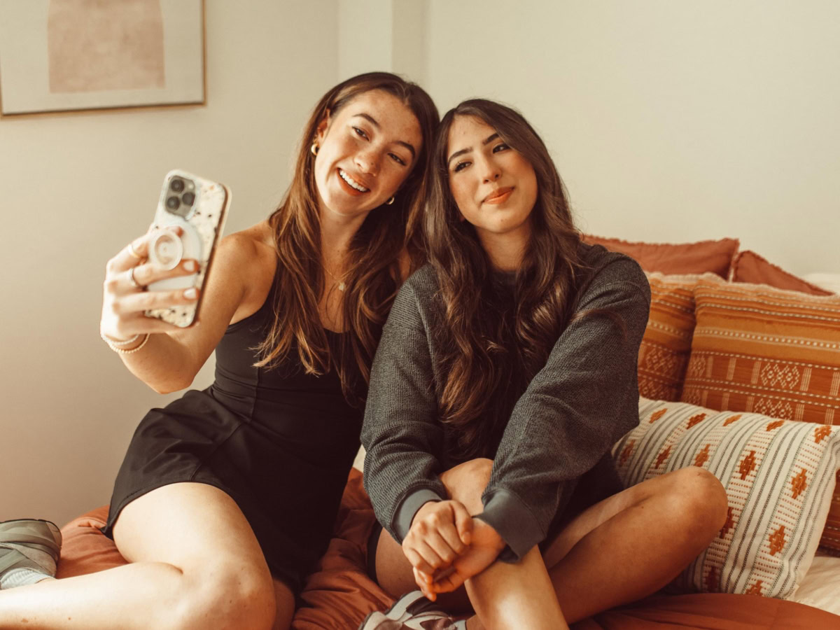 two girls sitting on a bed taking a selfie at Rambler ATX