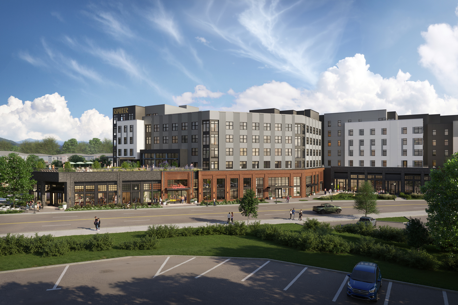 Modern multi-story building with gray and white exterior, ground-floor shops, and large windows, surrounded by greenery, a few parked cars, and people walking along the sidewalk under a partly cloudy sky.