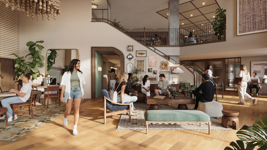 A modern, spacious coworking area designed with Rambler Blacksburg student housing in mind, where people are talking, working on laptops, and relaxing on couches. Large windows, wooden floors, and decorative art create a warm, inviting atmosphere perfect for collaboration and productivity.