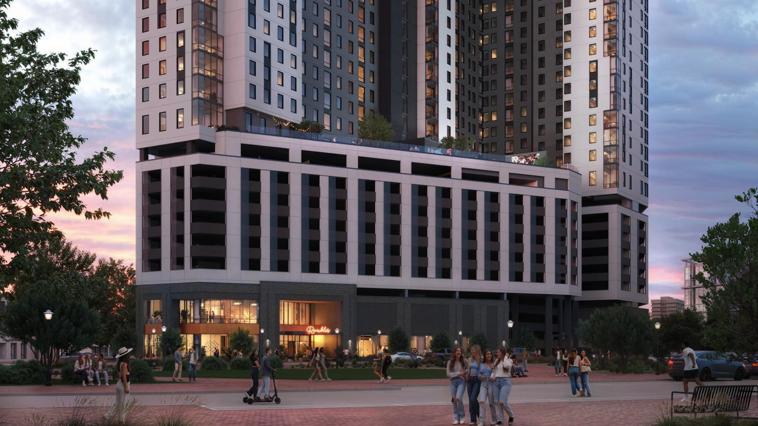A modern high-rise apartment building designed for Gainesville student housing, with shops at street level and people gathering outside at sunset. Trees and benches line the wide sidewalk in front, creating a welcoming atmosphere.