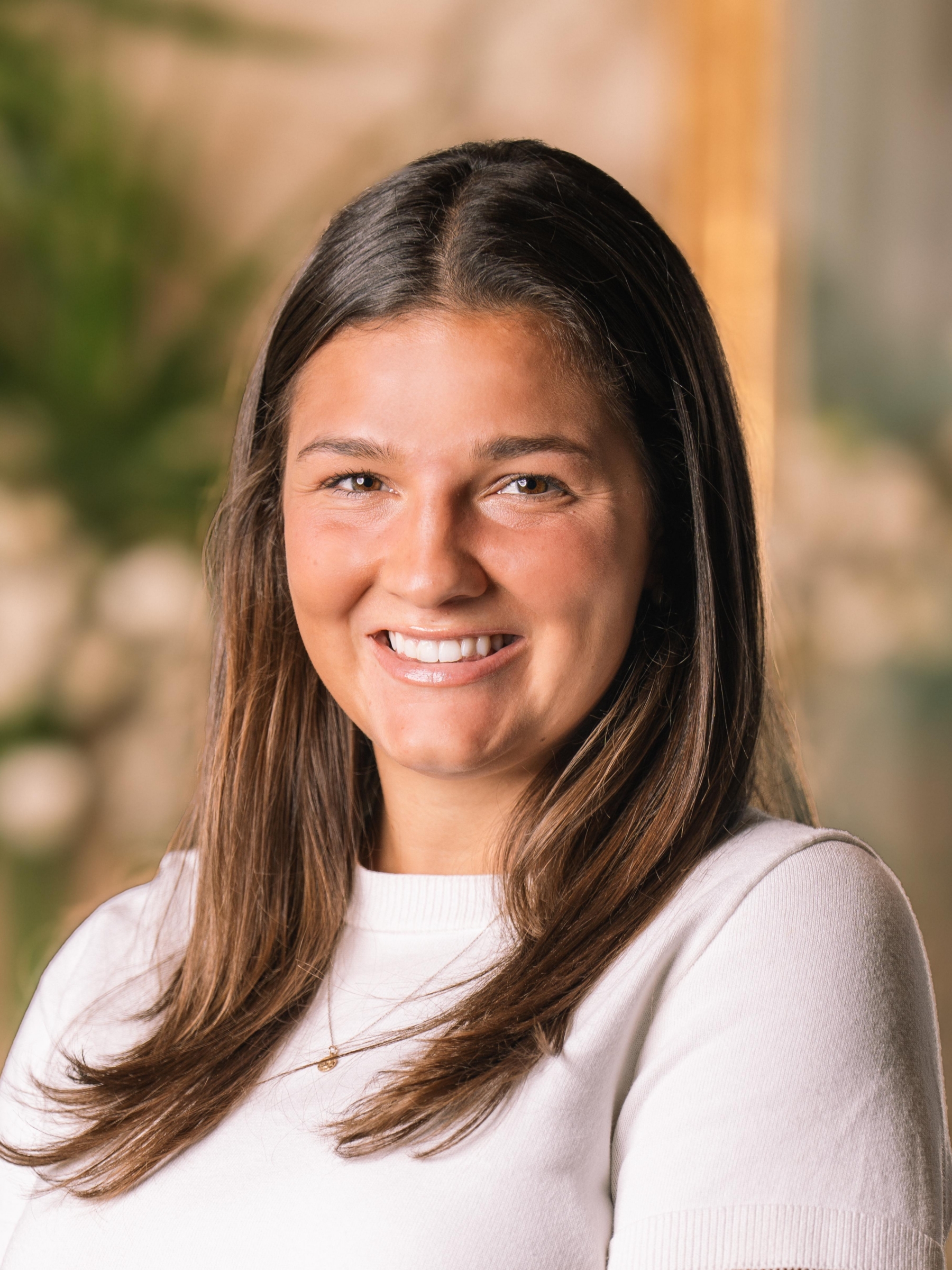 Claire Stoeckinger is a young woman with long brown hair smiling at the camera.